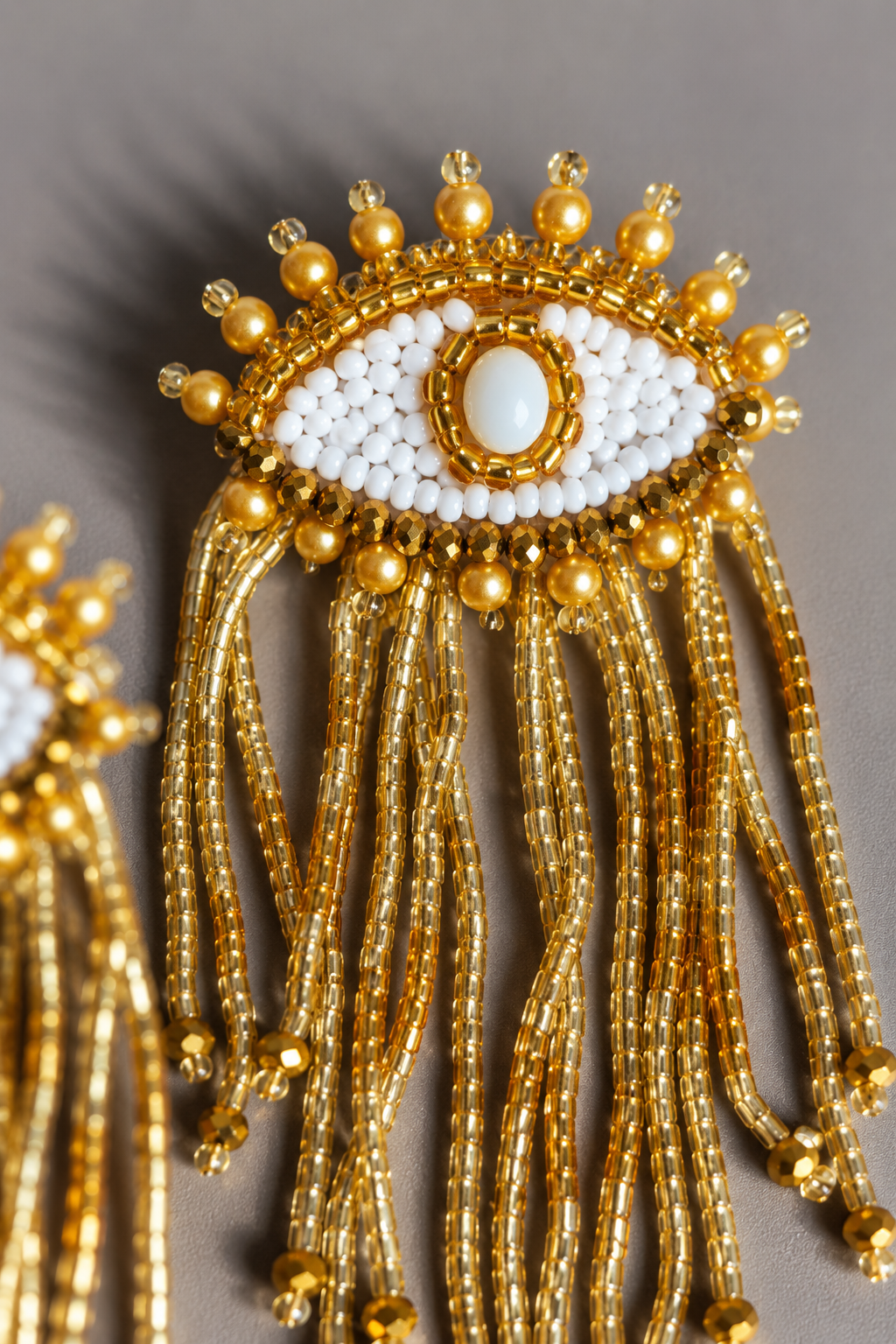 Hermosos aretes Buena suerte dorados en forma de ojos con flecos de mostacillas y cristales.
