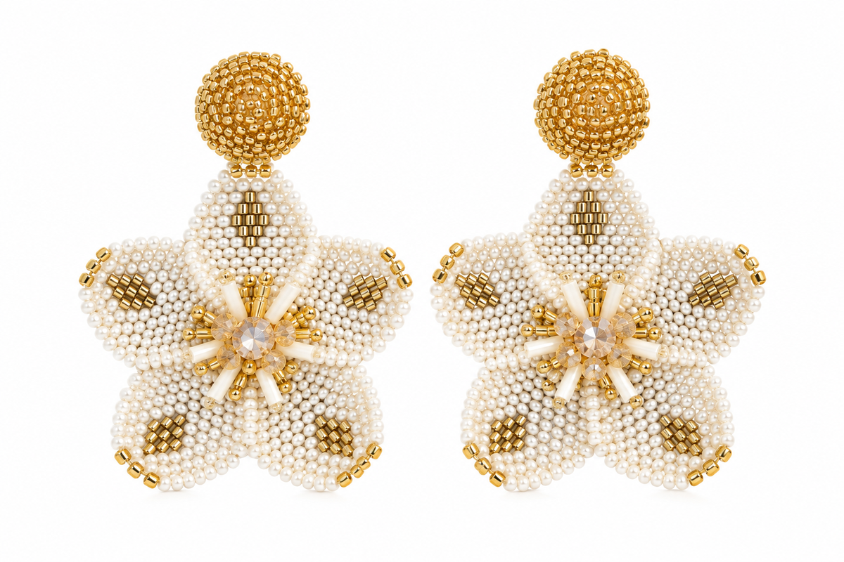 Los aretes Margarita destacan por su diseño en forma de flor, ideal para brillar en fiestas y eventos. Bordados a mano por artesanas colombianas, están disponibles en dorado o plateado