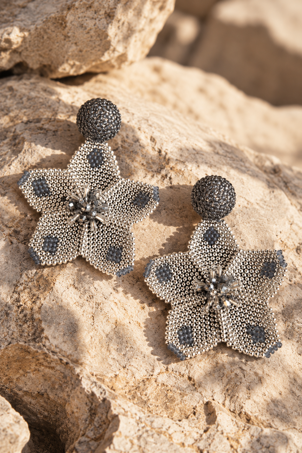 Los aretes Margarita destacan por su diseño en forma de flor en color plata y gris